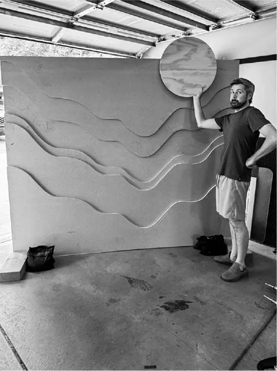 The unpainted set wall: layered wavy plywood panels with a round sun held up in one corner.