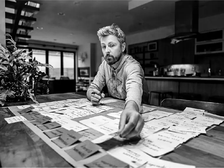 Sorting sticky notes across a dining table.